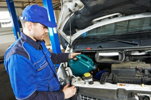 Technician Filling Car with Oil