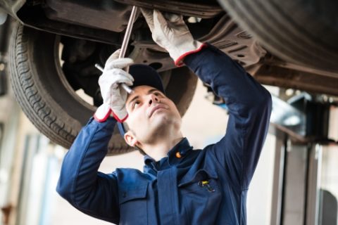 Mechanic Repairing Lifted Car